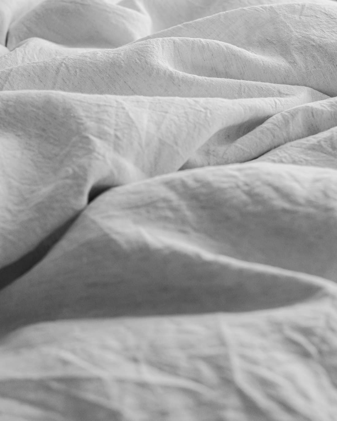 A close view of soft washed linen folded in daylight.